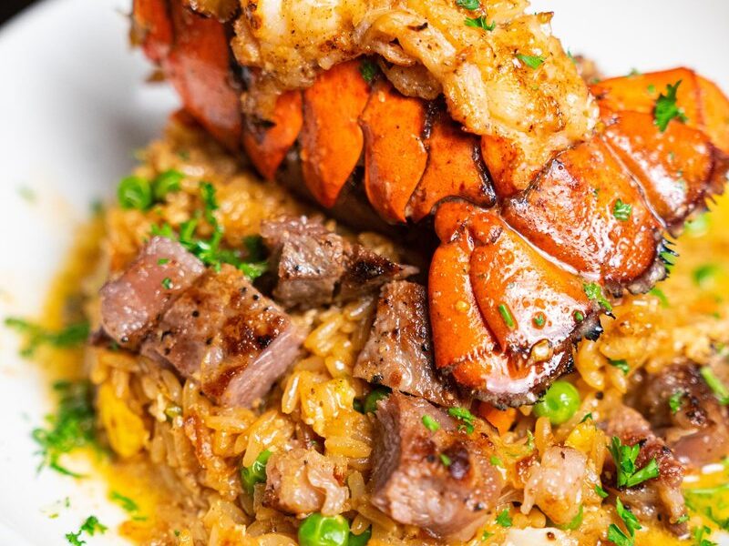 A lobster and steak surf and turf plate over rice at Seaside Lounge